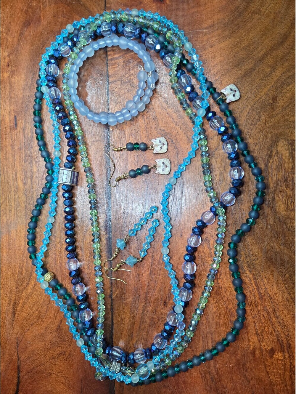 Set of Blue and Green Beaded Necklaces, Bracelets, and Cat